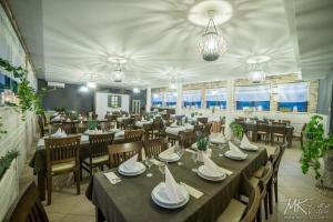 Montebello Bussines & SPA في أوسترون: غرفة طعام مع طاولات وكراسي في مطعم