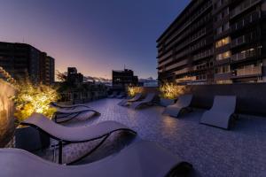 a rooftop patio with chairs and lights at night at Sauna Hotel Gifu in Gifu