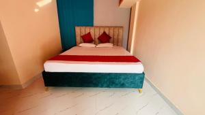 a small bedroom with a bed with red pillows at Royal Stay in Sibsāgar