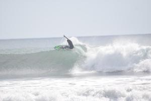 a person riding a wave on a surfboard in the ocean at Buena Onda Surf House in Las Peñitas