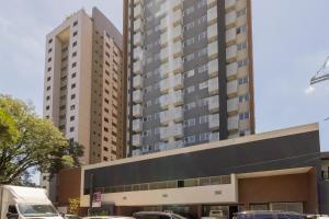 a large building with cars parked in front of it at BHomy Romana in Sao Paulo
