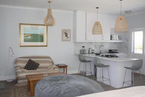a kitchen and living room with a couch and a table at Happy's Hood in Pringle Bay