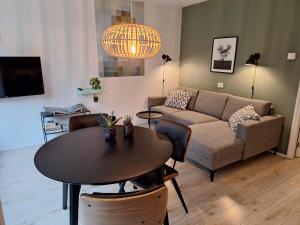 a living room with a table and a couch at Hoefbos Otterlo Bungalow in Otterlo