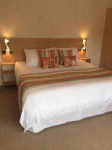 um quarto com uma grande cama branca com almofadas em The Beaucliffe em Blackpool
