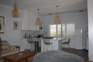 a kitchen with a counter and bar stools in it at Happy's Hood in Pringle Bay +31 photos