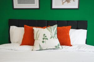 a green bedroom with a bed with orange and white pillows at Spacious 5 Bed 3 Bath Gatwick House in Crawley