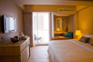 Cette chambre comprend un grand lit et un miroir. dans l'établissement AYA Boutique Hotel Pattaya - SHA Plus, à Pattaya