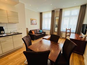 a kitchen and a living room with a table and chairs at Apartment Central Leipzig-Zoo in Leipzig