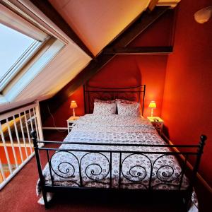 a bedroom with a bed with red walls and windows at Wijnstaete in Lemelerveld