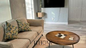 een woonkamer met een bank en een salontafel bij The Little Blue House Kenwood Ping Pong Hockey Family in St Petersburg