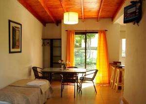 Amaikén Suites في نونو: غرفة طعام مع طاولة وكراسي ونافذة