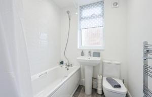 y baño blanco con aseo, bañera y lavamanos. en 3 Bed House, Free Parking, Garden, en Ince-in-Makerfield 11 fotos más