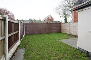 un patio trasero con una valla y un patio en 3 Bed House, Free Parking, Garden, en Ince-in-Makerfield