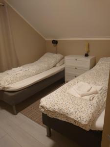 a bedroom with two beds and a dresser at Russelv panorama in Russelv