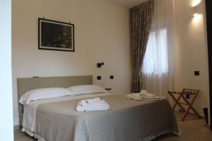 Massascusaにあるvilla ascosa residenceのタオルが敷かれたベッドのある寝室