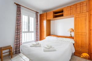 a bedroom with a bed with two towels on it at Apartamentos Arenal by Cádiz Time in Conil de la Frontera