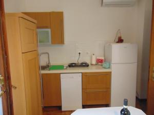 a kitchen with a white refrigerator and wooden cabinets at Podere Luma Camera Gelsomino - Lavanda in Gambassi Terme
