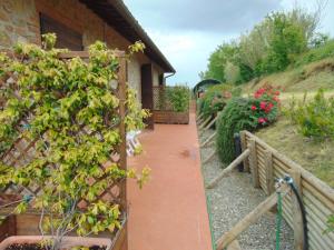 a garden with a brick walkway next to a house at Podere Luma Camera Gelsomino - Lavanda in Gambassi Terme +6 photos