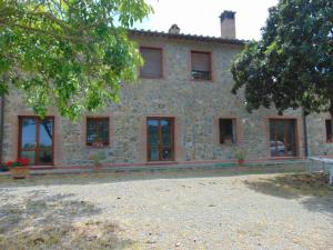 a large stone building with windows and a tree at Podere Luma Camera Gelsomino - Lavanda in Gambassi Terme