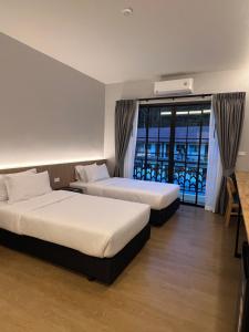 two beds in a hotel room with a balcony at PP Sweet House Khaolak พีพี สวีทเฮ้าส์ เขาหลัก in Ban Lam Ru (1) +54 photos