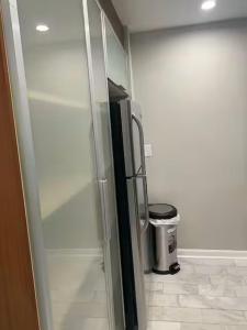 Un refrigerador de cristal en una habitación con un bote de basura. en Charming 2bd apartment with AC Wi-Fi in Atlanta, en Atlanta