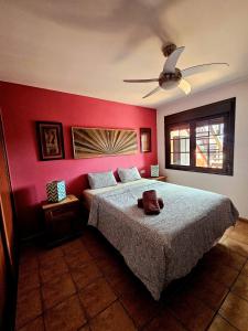 a bedroom with a bed with a red wall at Casalegre in Cotillo
