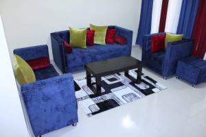 un soggiorno con due divani blu e un tavolo di Clayton's place a Bujumbura International Airport