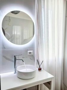 a white bathroom with a sink and a mirror at Villa del Pino, Terrazza vista Mare in Minturno