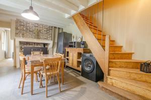 a kitchen and dining room with a table and a staircase at Le Petit Cosy Champenois in Lesmont +4 photos