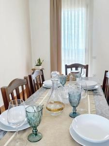 a table with plates and wine glasses on it at Villa del Pino, Terrazza vista Mare in Minturno