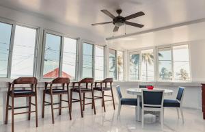 ein Esszimmer mit Tisch und Stühlen sowie einem Deckenventilator in der Unterkunft Bonefish Hotel in Dangriga