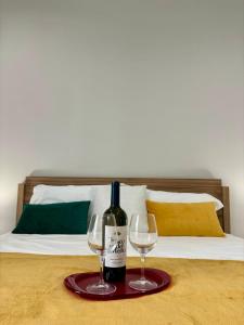 una bottiglia di vino e due bicchieri su un letto di Renda36 a Carini