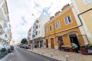 una calle con un edificio amarillo al lado de la carretera en Golden Place - Cacilhas, en Almada