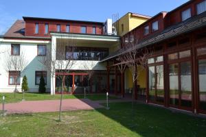 a group of buildings with trees in front of them at Althann Vendégház és Konferencia Központ in Vác