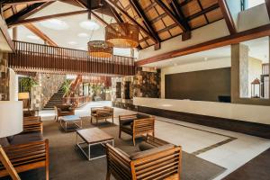 a lobby of a hotel with chairs and tables at Crystals Beach Resort Belle Mare, a member of Radisson Individuals in Belle Mare