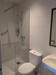 a bathroom with a shower and a toilet and a sink at Apartamentos Mitus in Canet de Mar +17 photos