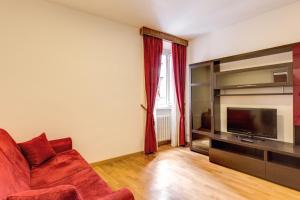 ローマにあるアポロ アパートメンツ コロッセオのリビングルーム(赤いソファ、テレビ付)
