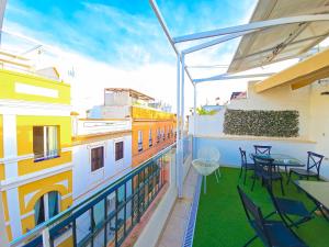 ein Balkon mit Tischen und Stühlen auf einem Gebäude in der Unterkunft Hostel A2C in Sevilla