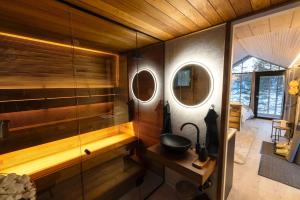 a bathroom with a shower with a sink and two mirrors at Hossaville Luxe West Lake Cabin in Hossa