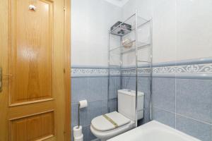 a bathroom with a white toilet and a wooden door at Puerta al encanto, descubre Tuy by CABANA Rentals in Tui