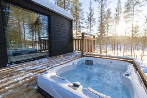 a jacuzzi tub on the deck of a house at Hossaville Luxe West Lake Cabin in Hossa