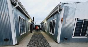 two people walking down a hallway between two buildings at Departamentos temporarios Rg in Río Grande +3 photos