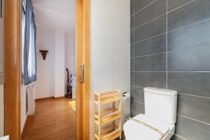 a bathroom with a white toilet in a room at Con parking y vistas al mar by CABANA Rentals in A Guarda +12 photos