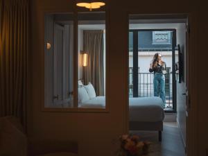 a woman standing on a balcony in a hotel room at Quartier Libre Opera in Paris