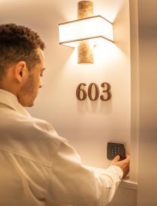 a man is looking at a clock on a wall at Quartier Libre Opera in Paris