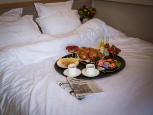 a tray of food and drinks on a bed at Quartier Libre Opera in Paris