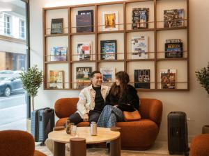 a man and a woman sitting on a couch at Quartier Libre Opera in Paris