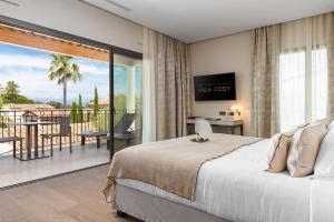 a bedroom with a bed and a balcony with a view at Villa Cosy, hotel & spa in Saint-Tropez