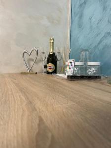a bottle of champagne and glasses on a wooden table at Love Room in Baia Mare