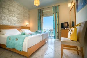 a bedroom with a bed and a chair and a window at Plaza Hotel in Zakynthos